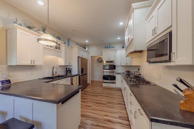 1614 8th St, Grand Rapids, MN 55744 - kitchen with a sink, stainless steel appliances, dark countertops, a peninsula, and backsplash
