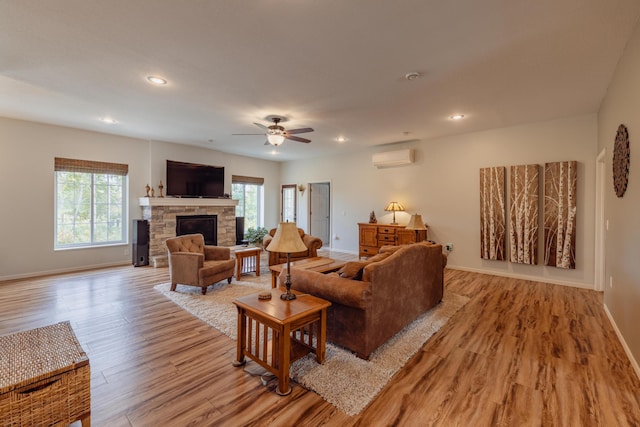 1614 8th St, Grand Rapids, MN 55744 - living room featuring a wall unit AC, light wood finished floors, baseboards, a fireplace, and recessed lighting