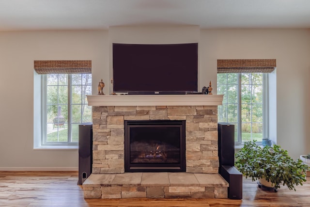1614 8th St, Grand Rapids, MN 55744 - detailed view of wood finished floors, a stone fireplace, and baseboards