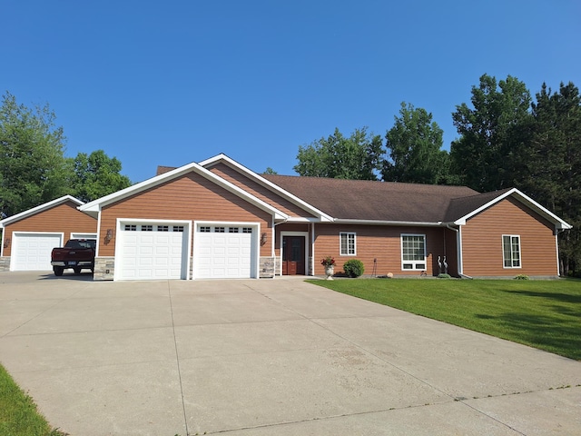 1614 8th St, Grand Rapids, MN 55744 - ranch-style home with a front yard, driveway, stone siding, and an attached garage