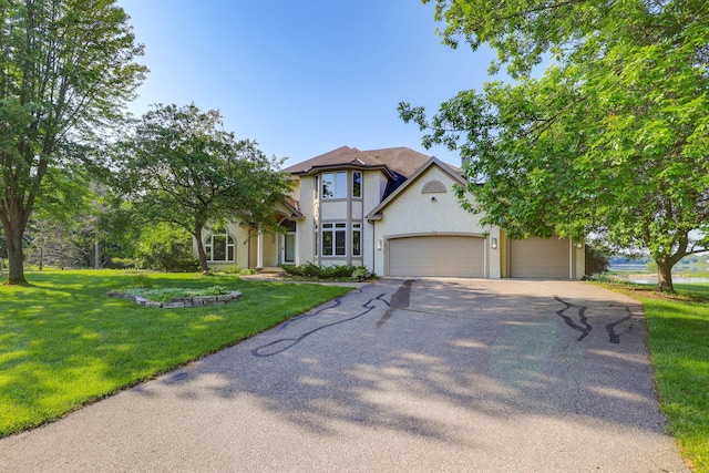 18715 24th Ave N, Plymouth, MN 55447 - tudor-style house with driveway, stucco siding, an attached garage, and a front yard
