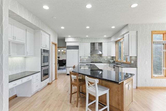 18715 24th Ave N, Plymouth, MN 55447 - kitchen with wall chimney exhaust hood, appliances with stainless steel finishes, light wood-type flooring, decorative backsplash, and white cabinets