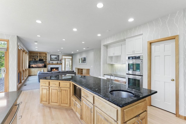 18715 24th Ave N, Plymouth, MN 55447 - kitchen with stainless steel double oven, a sink, light wood finished floors, recessed lighting, and a center island with sink