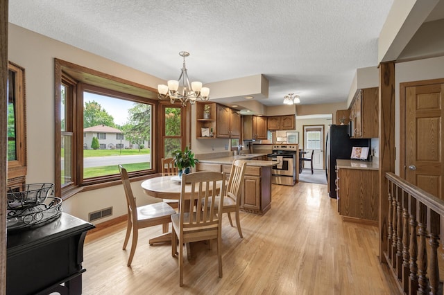 9452 Stevens Ave S, Bloomington, MN 55420 - dining space with a chandelier, light wood-style flooring, and a textured ceiling