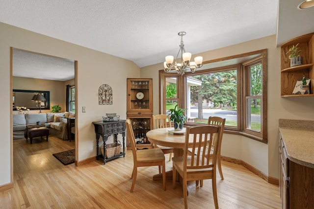 9452 Stevens Ave S, Bloomington, MN 55420 - dining space with light wood finished floors, a chandelier, baseboards, and a textured ceiling