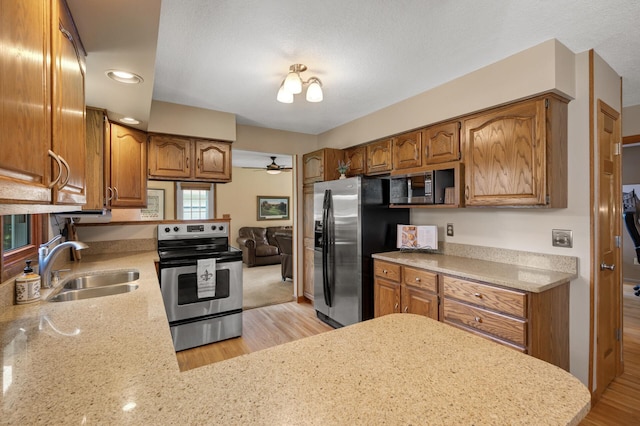 9452 Stevens Ave S, Bloomington, MN 55420 - kitchen featuring stainless steel appliances, a sink, brown cabinetry, and a peninsula