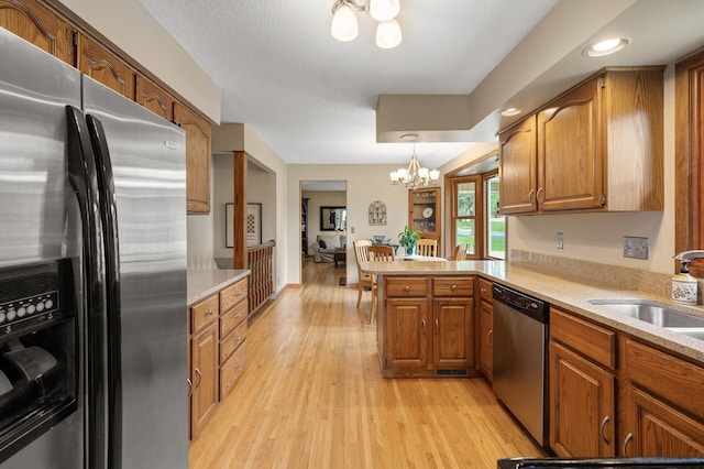9452 Stevens Ave S, Bloomington, MN 55420 - kitchen featuring stainless steel appliances, a peninsula, brown cabinets, a chandelier, and recessed lighting