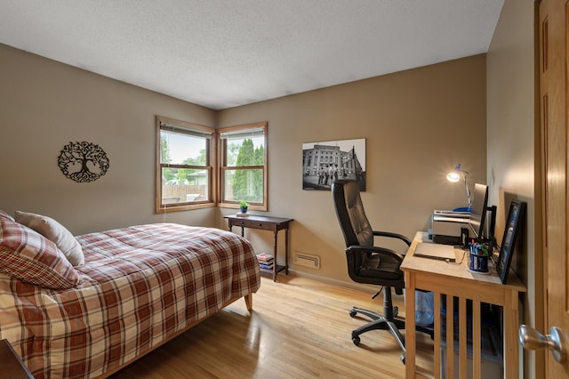 9452 Stevens Ave S, Bloomington, MN 55420 - bedroom featuring wood finished floors, a desk, a textured ceiling, and baseboards