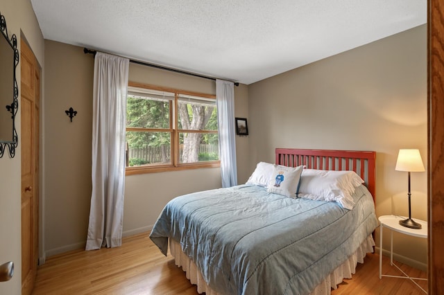 9452 Stevens Ave S, Bloomington, MN 55420 - bedroom featuring light wood-style flooring, baseboards, and a textured ceiling