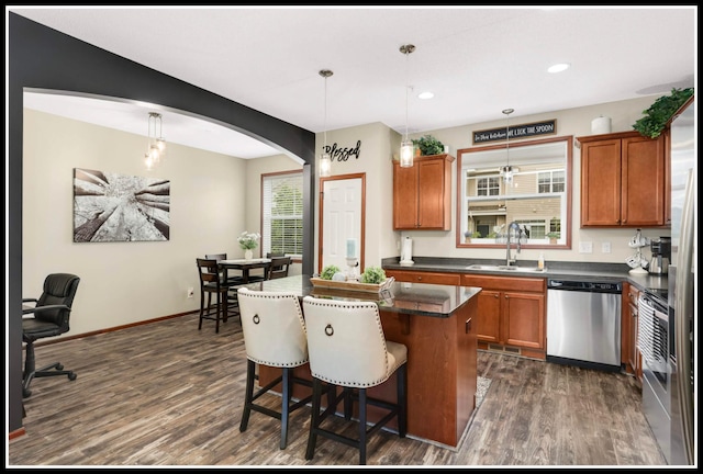 8065 Kirkwood Ln N Unit 82, Maple Grove, MN 55369 - kitchen featuring dishwasher, a center island, brown cabinets, dark wood-style floors, and a breakfast bar area