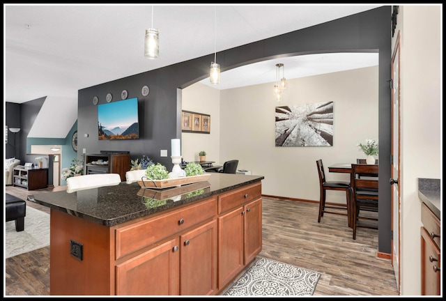 8065 Kirkwood Ln N Unit 82, Maple Grove, MN 55369 - kitchen with wood finished floors, open floor plan, brown cabinetry, dark stone countertops, and hanging light fixtures