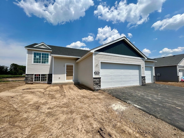 6720 376th St, North Branch, MN 55056 - view of front of property featuring driveway, an attached garage, and stone siding