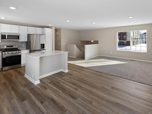 6720 376th St, North Branch, MN 55056 - kitchen featuring appliances with stainless steel finishes, white cabinetry, a center island, dark wood-style floors, and light countertops