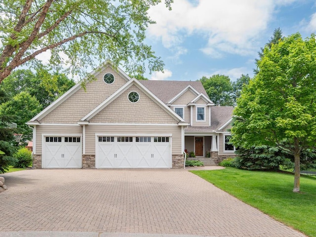 1776 Lockridge Ct, Waconia, MN 55387 - craftsman-style house featuring stone siding, decorative driveway, an attached garage, and a front lawn