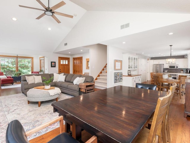 1776 Lockridge Ct, Waconia, MN 55387 - dining space with light wood-style floors, stairs, high vaulted ceiling, ceiling fan, and recessed lighting