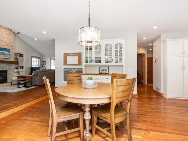 1776 Lockridge Ct, Waconia, MN 55387 - dining space with light wood-style flooring, a fireplace, recessed lighting, lofted ceiling, and a chandelier