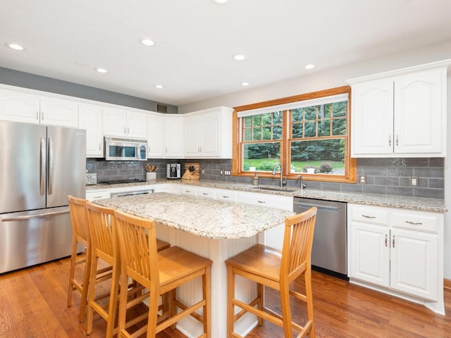 1776 Lockridge Ct, Waconia, MN 55387 - kitchen with appliances with stainless steel finishes, a sink, a kitchen breakfast bar, tasteful backsplash, and recessed lighting