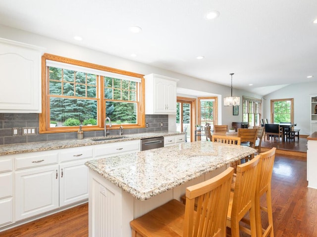 1776 Lockridge Ct, Waconia, MN 55387 - kitchen with dark wood-type flooring, a center island, backsplash, stainless steel dishwasher, and a breakfast bar