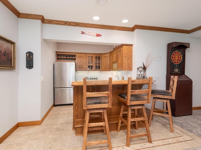 1776 Lockridge Ct, Waconia, MN 55387 - kitchen with freestanding refrigerator, crown molding, glass insert cabinets, baseboards, and brown cabinets