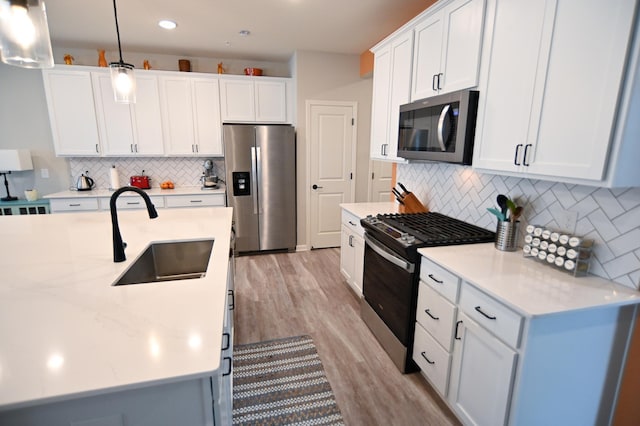 4837 Avery Ct, Eagan, MN 55123 - kitchen featuring stainless steel appliances, tasteful backsplash, light wood-style flooring, white cabinetry, and decorative light fixtures