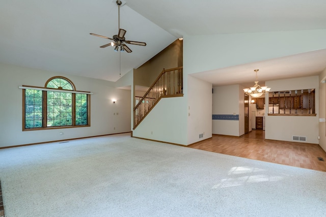 957 Belvista Dr, North Mankato, MN 56003 - unfurnished living room with carpet floors, high vaulted ceiling, a chandelier, a ceiling fan, and stairway
