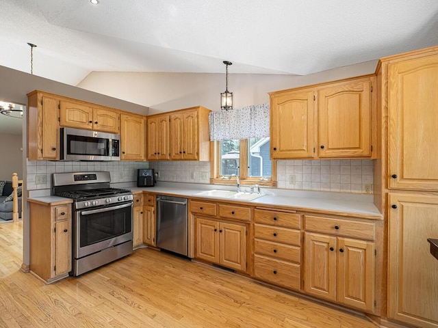5956 Norway Pine Ct, White Bear Twp, MN 55110 - kitchen with stainless steel appliances, a sink, light countertops, light wood-style flooring, and vaulted ceiling
