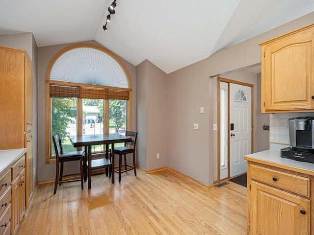 5956 Norway Pine Ct, White Bear Twp, MN 55110 - kitchen with vaulted ceiling, light wood-style floors, light countertops, baseboards, and tasteful backsplash