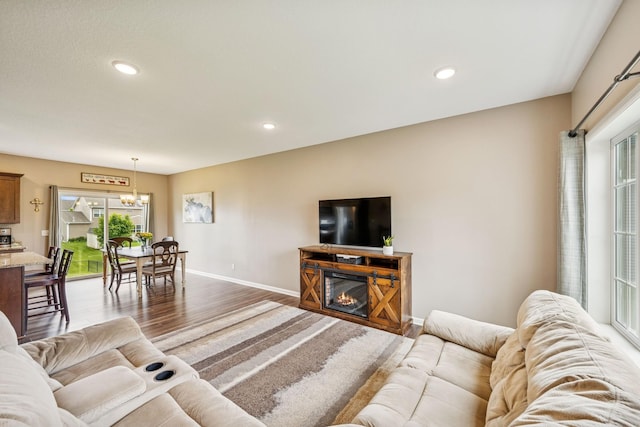 12083 79th St NE, Otsego, MN 55330 - living area with wood finished floors, baseboards, recessed lighting, a chandelier, and a glass covered fireplace