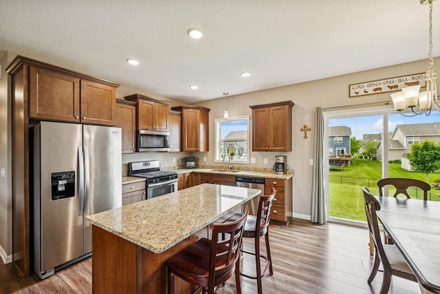 12083 79th St NE, Otsego, MN 55330 - kitchen with appliances with stainless steel finishes, wood finished floors, plenty of natural light, light stone counters, and recessed lighting