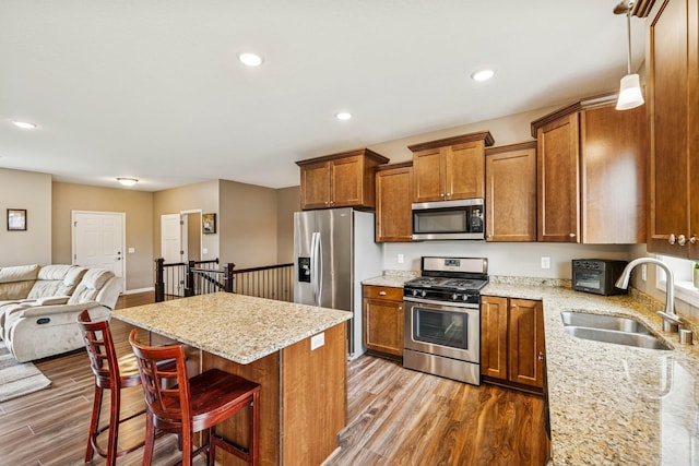 12083 79th St NE, Otsego, MN 55330 - kitchen featuring appliances with stainless steel finishes, a sink, brown cabinetry, dark wood-type flooring, and open floor plan