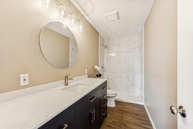 12083 79th St NE, Otsego, MN 55330 - full bathroom featuring vanity, toilet, a marble finish shower, wood finished floors, and a textured ceiling