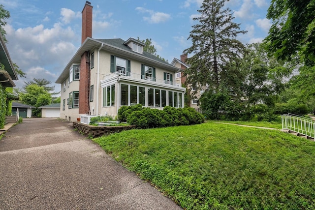 2516 Humboldt Ave S, Minneapolis, MN 55405 - view of front of house featuring a chimney, a balcony, an outbuilding, a front yard, and stucco siding
