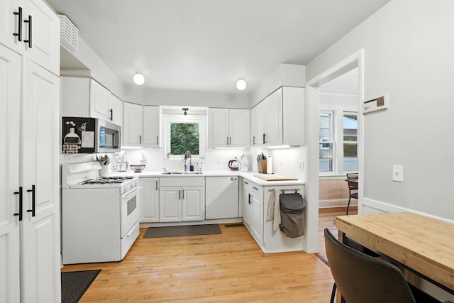 2516 Humboldt Ave S, Minneapolis, MN 55405 - kitchen featuring white appliances, white cabinets, light wood-style floors, and light countertops