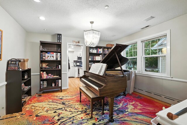 2516 Humboldt Ave S, Minneapolis, MN 55405 - living area with a baseboard radiator, a chandelier, a textured ceiling, wood finished floors, and recessed lighting