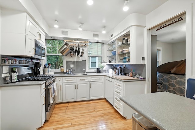 2516 Humboldt Ave S, Minneapolis, MN 55405 - kitchen featuring appliances with stainless steel finishes, white cabinetry, light wood-style flooring, and rail lighting