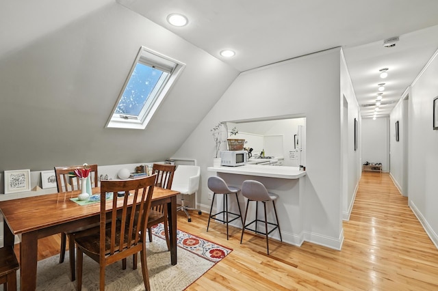 2516 Humboldt Ave S, Minneapolis, MN 55405 - dining area featuring a skylight, light wood-style floors, lofted ceiling, and recessed lighting