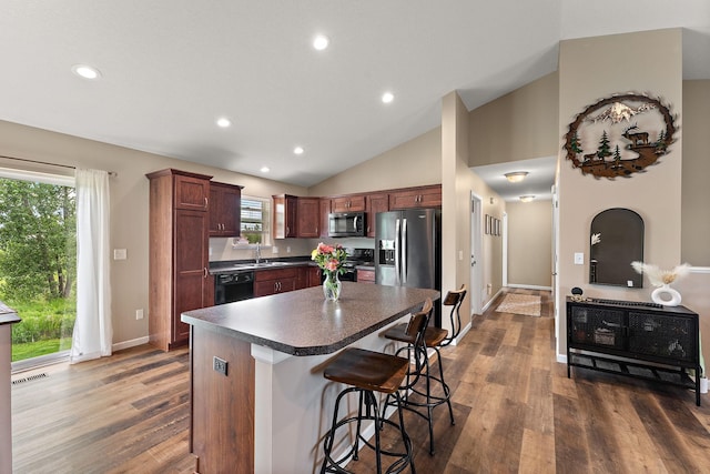 809 Cologne Ln, Waverly, MN 55390 - kitchen featuring black appliances, dark countertops, a kitchen bar, dark wood-style floors, and recessed lighting
