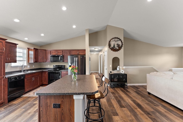 809 Cologne Ln, Waverly, MN 55390 - kitchen with black appliances, dark countertops, a breakfast bar area, vaulted ceiling, and a center island