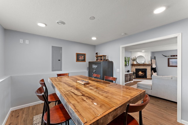 809 Cologne Ln, Waverly, MN 55390 - dining area featuring electric panel, wood finished floors, a fireplace, recessed lighting, and a textured ceiling