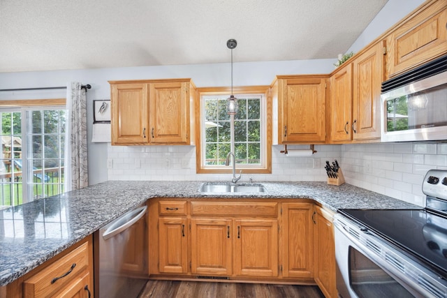 1590 Fountain Ln, Waconia, MN 55387 - kitchen featuring stainless steel appliances, a textured ceiling, stone countertops, and healthy amount of natural light