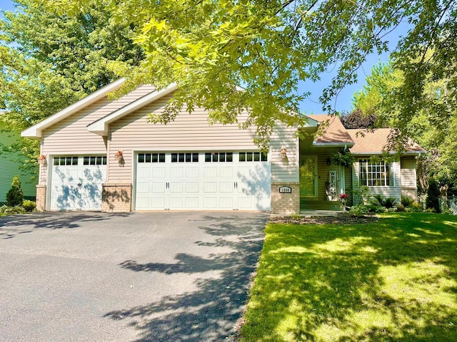 1590 Fountain Ln, Waconia, MN 55387 - view of front of home with brick siding, asphalt driveway, a front lawn, and a garage