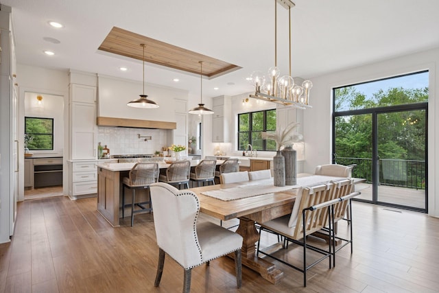 11278 Eastwood Ave SE, Delano, MN 55328 - dining area with light wood-style floors, a raised ceiling, a chandelier, and recessed lighting