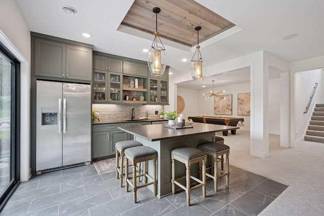 11278 Eastwood Ave SE, Delano, MN 55328 - kitchen with stainless steel fridge, a tray ceiling, dark countertops, a breakfast bar area, and recessed lighting