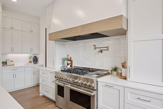 11278 Eastwood Ave SE, Delano, MN 55328 - kitchen featuring double oven range, custom range hood, tasteful backsplash, and white cabinetry