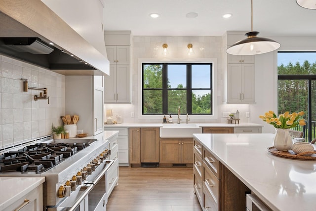 11278 Eastwood Ave SE, Delano, MN 55328 - kitchen with double oven range, wall chimney range hood, backsplash, recessed lighting, and light wood finished floors