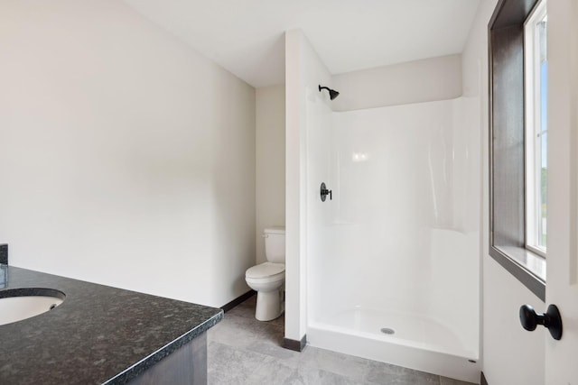 2660 128th Ave NW, Coon Rapids, MN 55434 - bathroom with toilet, vanity, a shower, baseboards, and tile patterned flooring