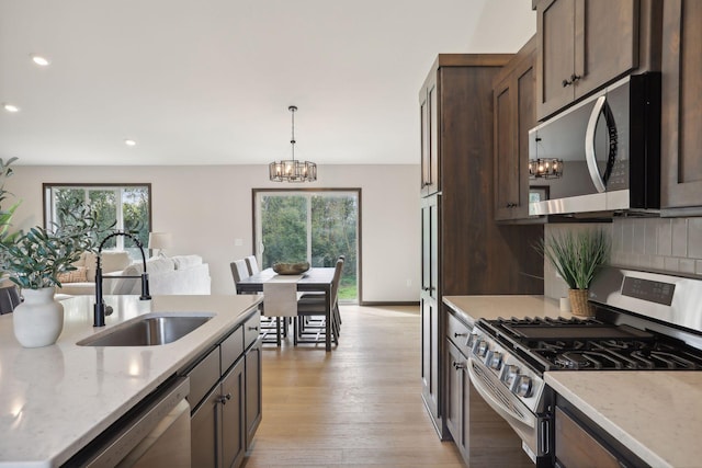 2660 128th Ave NW, Coon Rapids, MN 55434 - kitchen with appliances with stainless steel finishes, a sink, dark brown cabinets, plenty of natural light, and recessed lighting