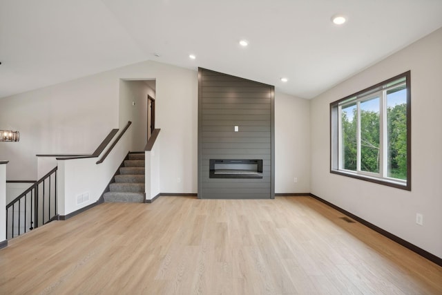 2660 128th Ave NW, Coon Rapids, MN 55434 - unfurnished living room with a fireplace, lofted ceiling, light wood-style flooring, baseboards, and recessed lighting