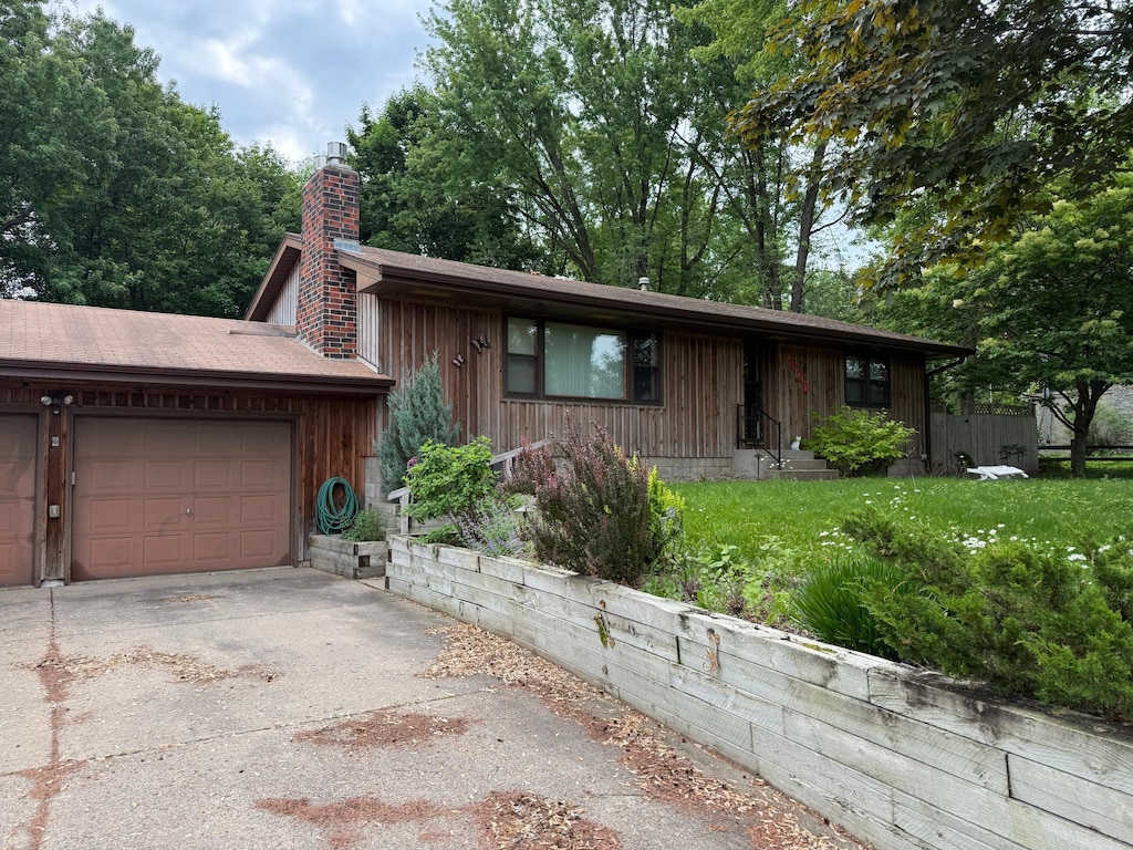 2820 Pilot Knob Rd, Eagan, MN 55121 - view of front of home with concrete driveway, a chimney, a garage, and a front yard