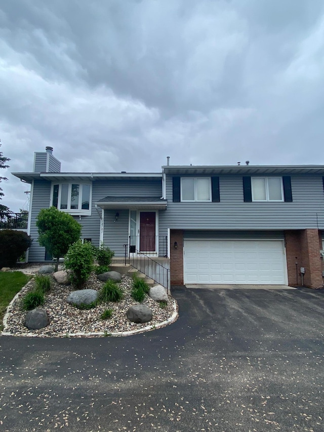 14781 Endicott Way, Apple Valley, MN 55124 - view of front of house featuring an attached garage, asphalt driveway, a chimney, and brick siding